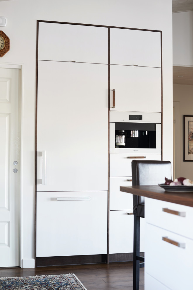 Inspiration for a medium sized scandi l-shaped open plan kitchen in Cheshire with a built-in sink, glass-front cabinets, white cabinets, wood worktops, grey splashback, stone tiled splashback, stainless steel appliances, vinyl flooring, an island, brown floors and brown worktops.