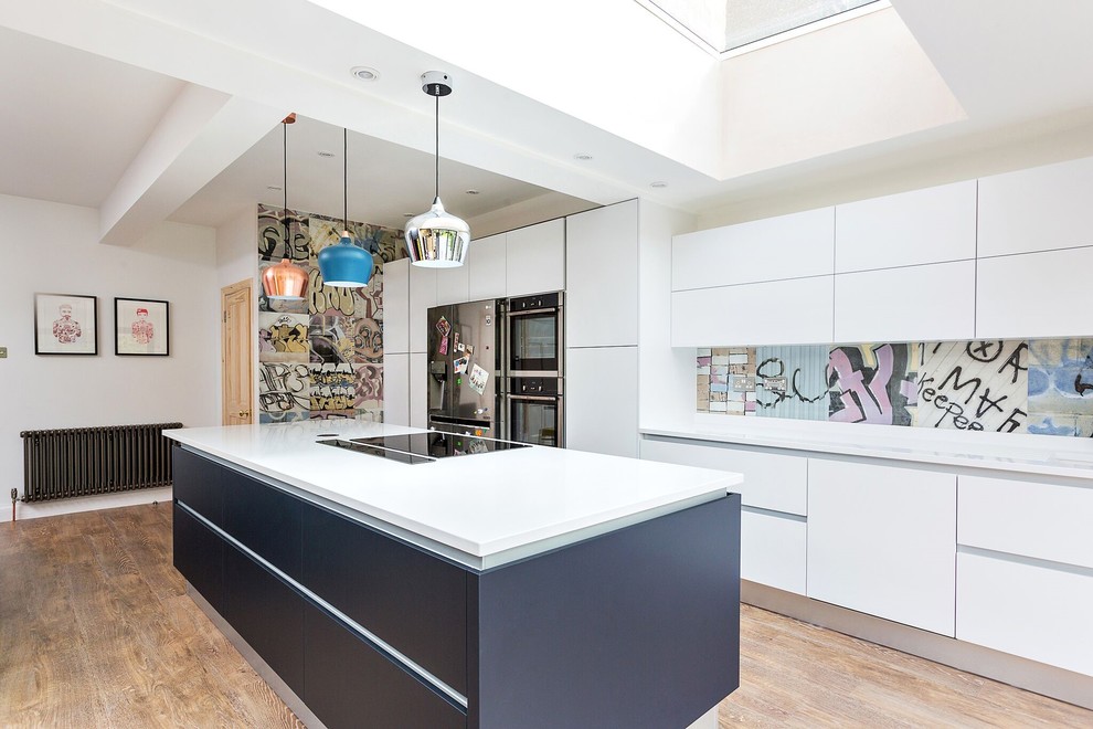 Einzeilige Moderne Küche mit flächenbündigen Schrankfronten, weißen Schränken, hellem Holzboden, Kücheninsel und Tapete in Sonstige