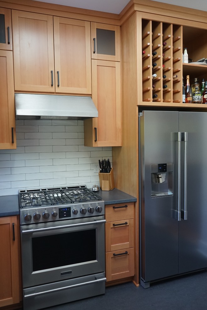 Enclosed kitchen - small modern linoleum floor enclosed kitchen idea in Portland with an undermount sink, shaker cabinets, light wood cabinets, concrete countertops, white backsplash, ceramic backsplash, stainless steel appliances and no island