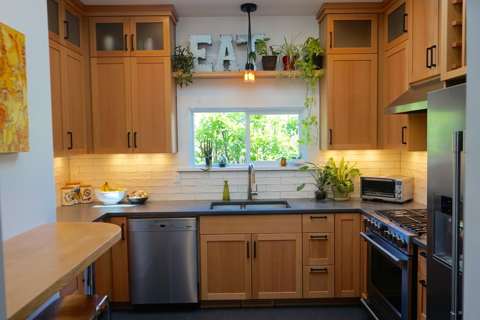 Foto på ett avskilt, litet lantligt u-kök, med en undermonterad diskho, skåp i shakerstil, skåp i ljust trä, bänkskiva i betong, vitt stänkskydd, stänkskydd i keramik, rostfria vitvaror och linoleumgolv