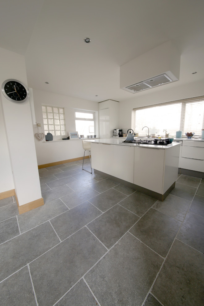 This is an example of a medium sized contemporary kitchen in Other with limestone flooring and an island.