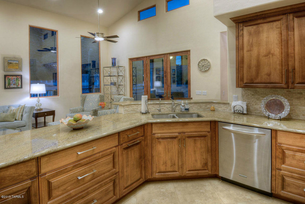 Mittelgroße Klassische Wohnküche in L-Form mit Einbauwaschbecken, profilierten Schrankfronten, braunen Schränken, Granit-Arbeitsplatte, Küchengeräten aus Edelstahl und Keramikboden in Phoenix
