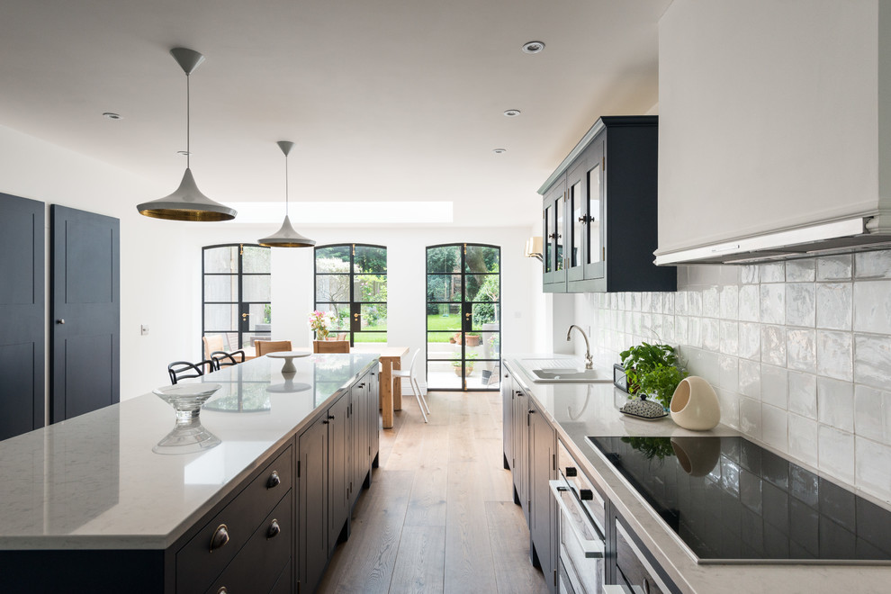 Idee per una cucina design di medie dimensioni con lavello da incasso, ante blu, pavimento in legno massello medio e pavimento marrone