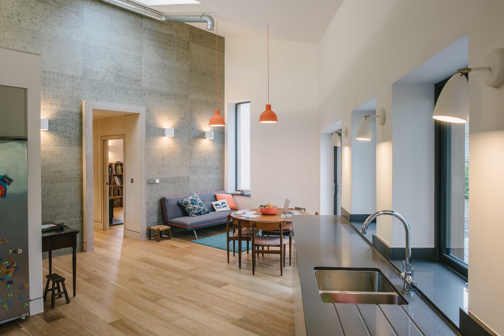 Offene Moderne Küche mit Doppelwaschbecken und hellem Holzboden in Sonstige