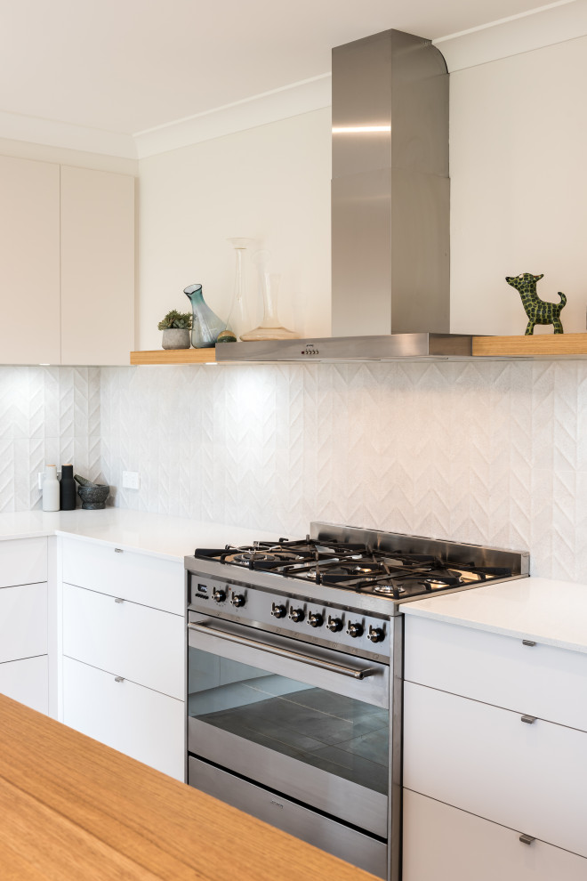 Idéer för ett mellanstort industriellt vit kök, med en undermonterad diskho, släta luckor, vita skåp, bänkskiva i kvarts, vitt stänkskydd, stänkskydd i mosaik, rostfria vitvaror, cementgolv, en köksö och grått golv