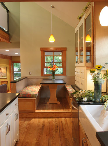 Exempel på ett litet klassiskt kök, med en rustik diskho, luckor med glaspanel, vita skåp, rostfria vitvaror, mellanmörkt trägolv och en köksö