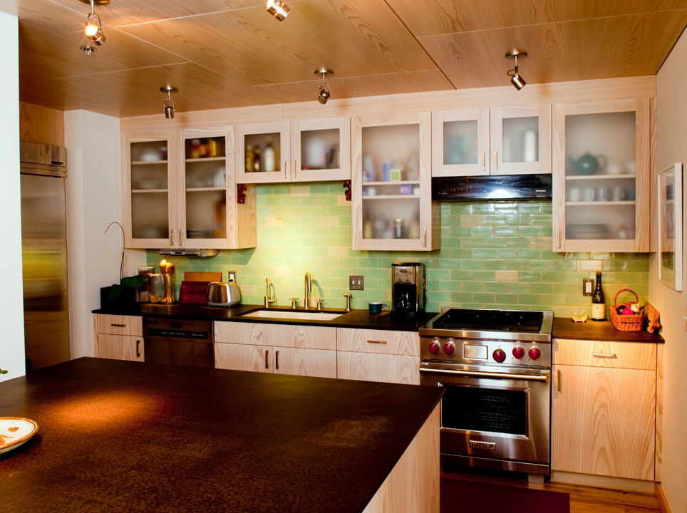Immagine di una cucina ad U design chiusa con lavello sottopiano, ante di vetro, ante in legno chiaro, paraspruzzi verde, paraspruzzi con piastrelle in ceramica e elettrodomestici in acciaio inossidabile