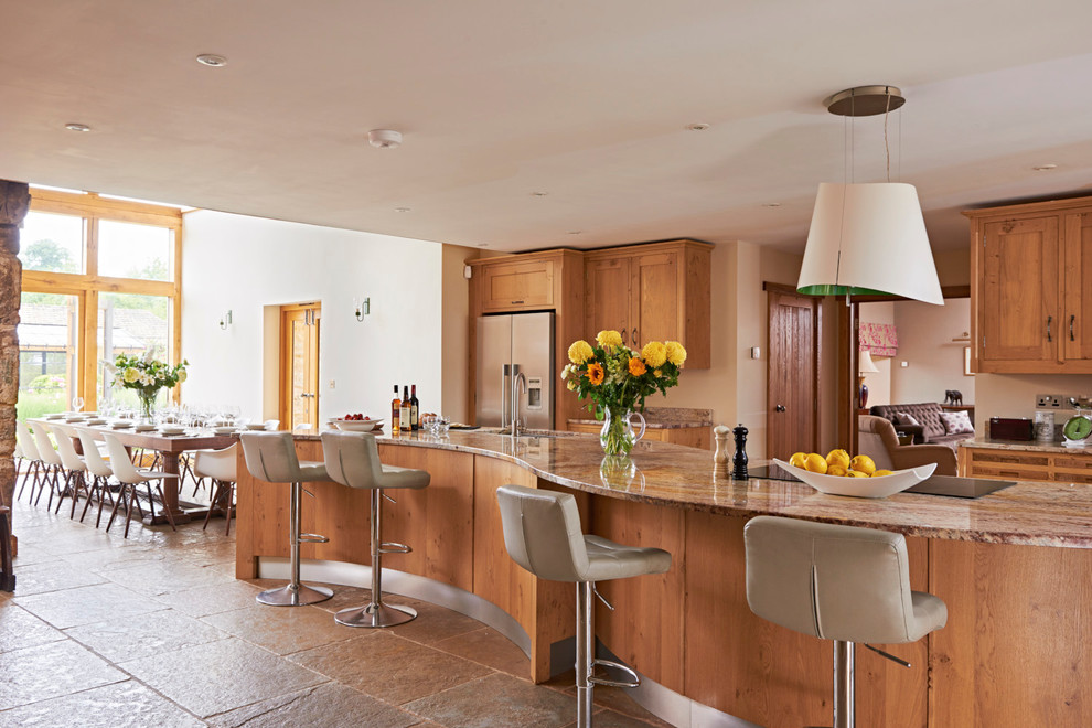 Bild på ett lantligt kök och matrum, med skåp i shakerstil, skåp i mellenmörkt trä, rostfria vitvaror och en köksö