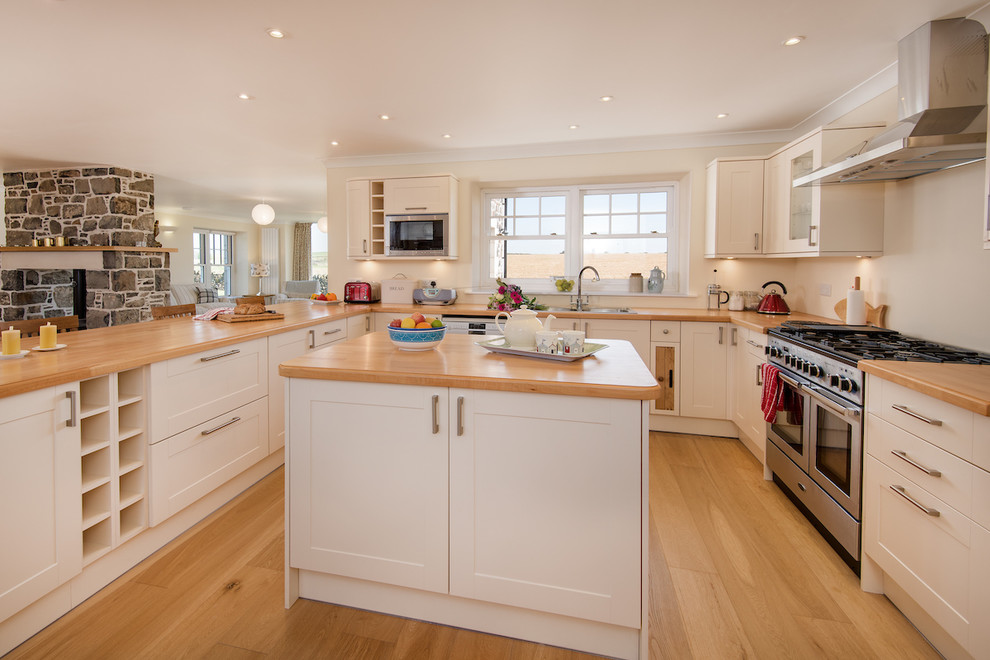 Inspiration for a large country u-shaped open plan kitchen in Edinburgh with recessed-panel cabinets, white cabinets, wood worktops and an island.