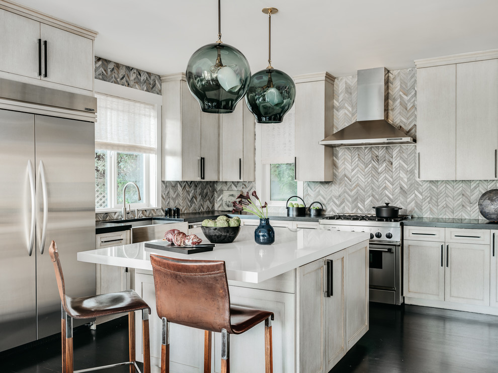 Design ideas for a traditional l-shaped kitchen in San Francisco with a belfast sink, shaker cabinets, white cabinets, grey splashback, mosaic tiled splashback, stainless steel appliances, dark hardwood flooring, an island, brown floors and white worktops.