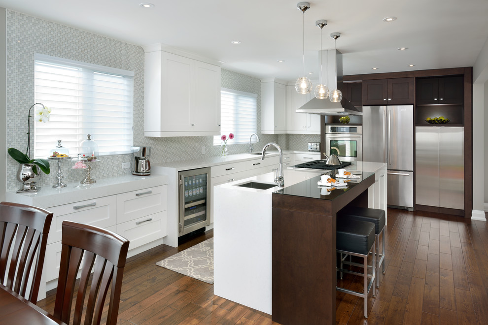 Eat-in kitchen - large transitional l-shaped dark wood floor eat-in kitchen idea in Toronto with an undermount sink, shaker cabinets, white cabinets, white backsplash, mosaic tile backsplash and stainless steel appliances