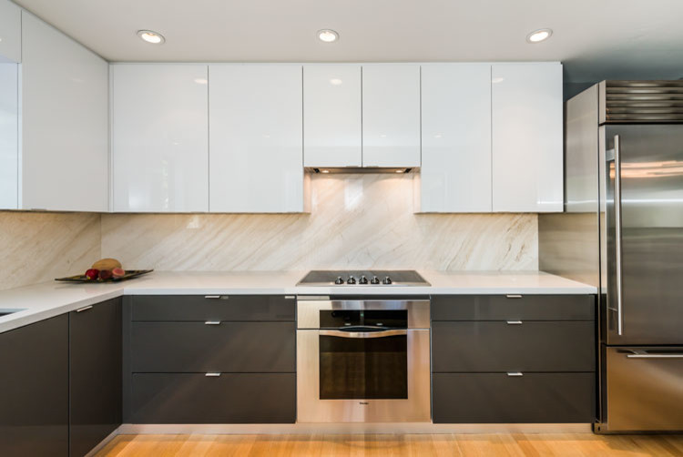 Bild på ett litet funkis kök, med en undermonterad diskho, släta luckor, vita skåp, bänkskiva i kvarts, stänkskydd i sten, rostfria vitvaror, ljust trägolv och flerfärgad stänkskydd