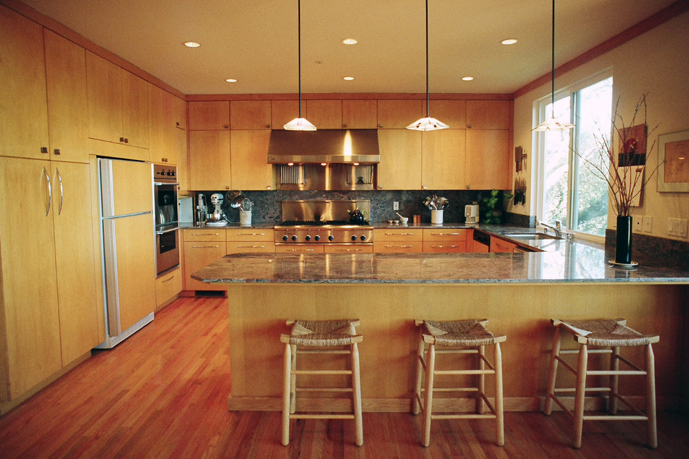 サンフランシスコにあるコンテンポラリースタイルのおしゃれなコの字型キッチン (フラットパネル扉のキャビネット、淡色木目調キャビネット、パネルと同色の調理設備) の写真