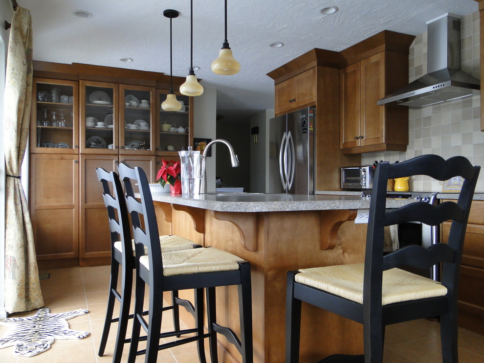 Amerikansk inredning av ett litet kök, med en dubbel diskho, luckor med infälld panel, skåp i mellenmörkt trä, bänkskiva i kalksten, beige stänkskydd, stänkskydd i keramik, rostfria vitvaror, linoleumgolv och en köksö