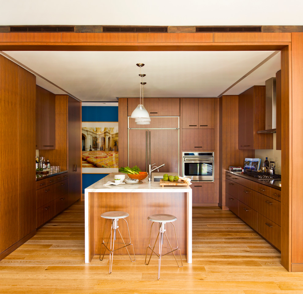 Idee per una cucina contemporanea chiusa e di medie dimensioni con ante in legno scuro, paraspruzzi bianco, elettrodomestici da incasso, parquet chiaro e top in marmo