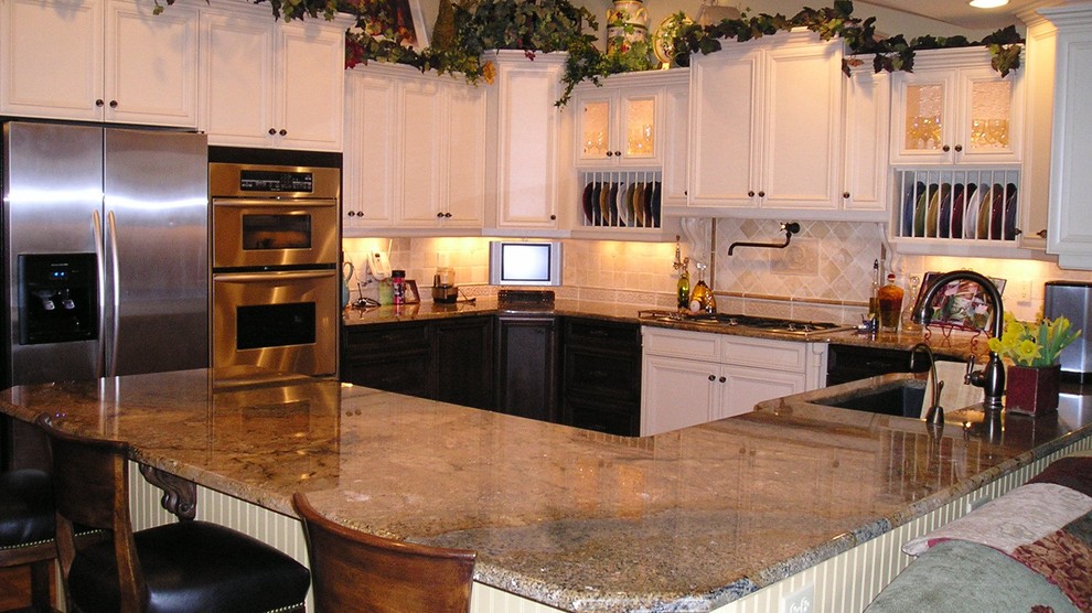 Exempel på ett mycket stort lantligt kök, med en undermonterad diskho, luckor med profilerade fronter, vita skåp, granitbänkskiva, beige stänkskydd, stänkskydd i stenkakel, rostfria vitvaror, målat trägolv och flera köksöar