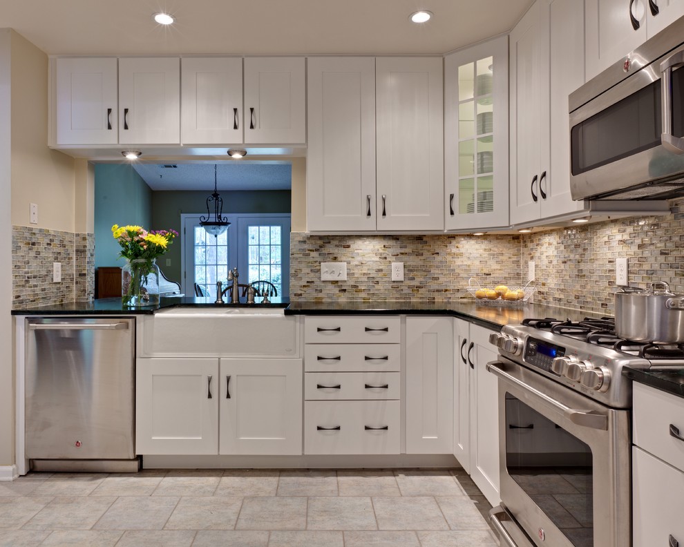 Inspiration for a small timeless u-shaped porcelain tile and beige floor eat-in kitchen remodel in Atlanta with a farmhouse sink, white cabinets, recessed-panel cabinets, soapstone countertops, multicolored backsplash, glass tile backsplash, stainless steel appliances, an island and green countertops