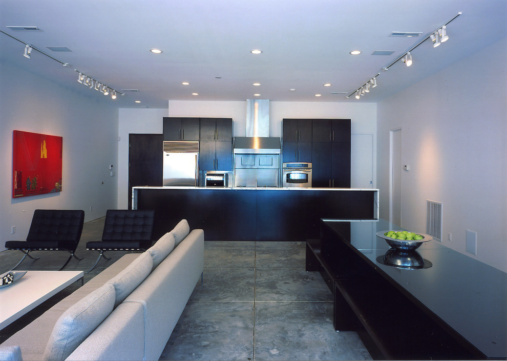 Foto de cocina moderna con puertas de armario negras, electrodomésticos de acero inoxidable y una isla