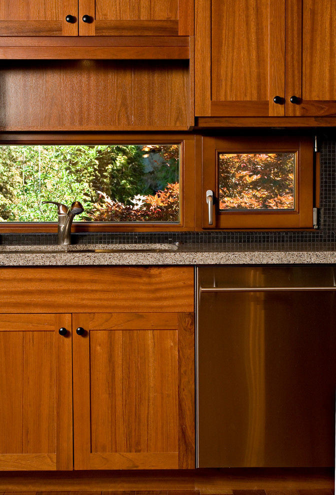 Foto på ett stort funkis kök, med en undermonterad diskho, skåp i shakerstil, skåp i mellenmörkt trä, granitbänkskiva, svart stänkskydd, stänkskydd i mosaik, rostfria vitvaror, mellanmörkt trägolv och en köksö