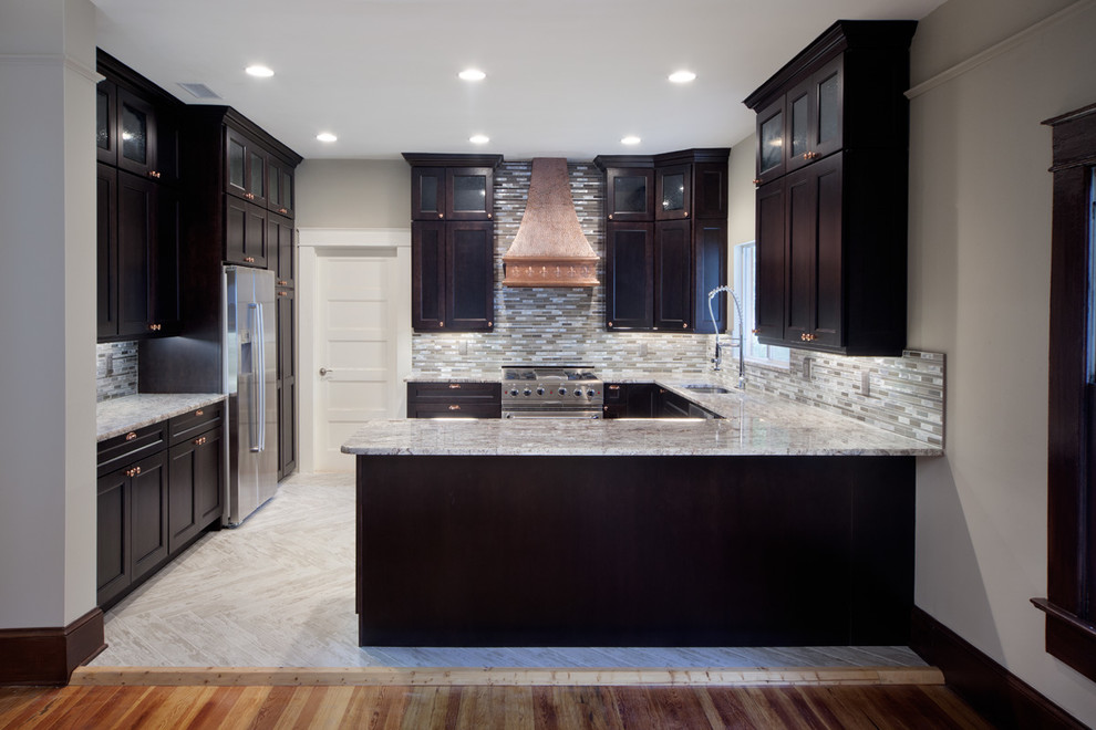 Eat-in kitchen - mid-sized modern u-shaped ceramic tile eat-in kitchen idea in Orlando with dark wood cabinets, granite countertops, metallic backsplash, glass tile backsplash, stainless steel appliances, an undermount sink, recessed-panel cabinets and an island