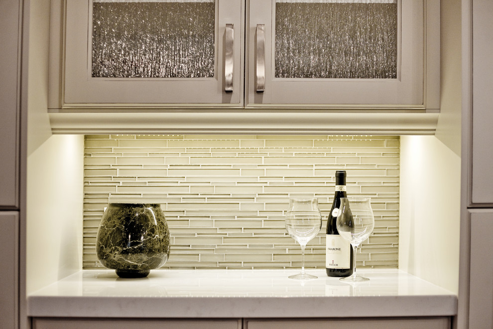 Moderne Küche mit Doppelwaschbecken, Glasfronten, weißen Schränken, Quarzit-Arbeitsplatte, Rückwand aus Glasfliesen, braunem Holzboden und Kücheninsel in Toronto