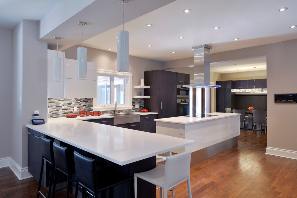 Example of a minimalist l-shaped medium tone wood floor eat-in kitchen design in Toronto with a farmhouse sink, flat-panel cabinets, dark wood cabinets, quartz countertops, gray backsplash, stainless steel appliances and an island