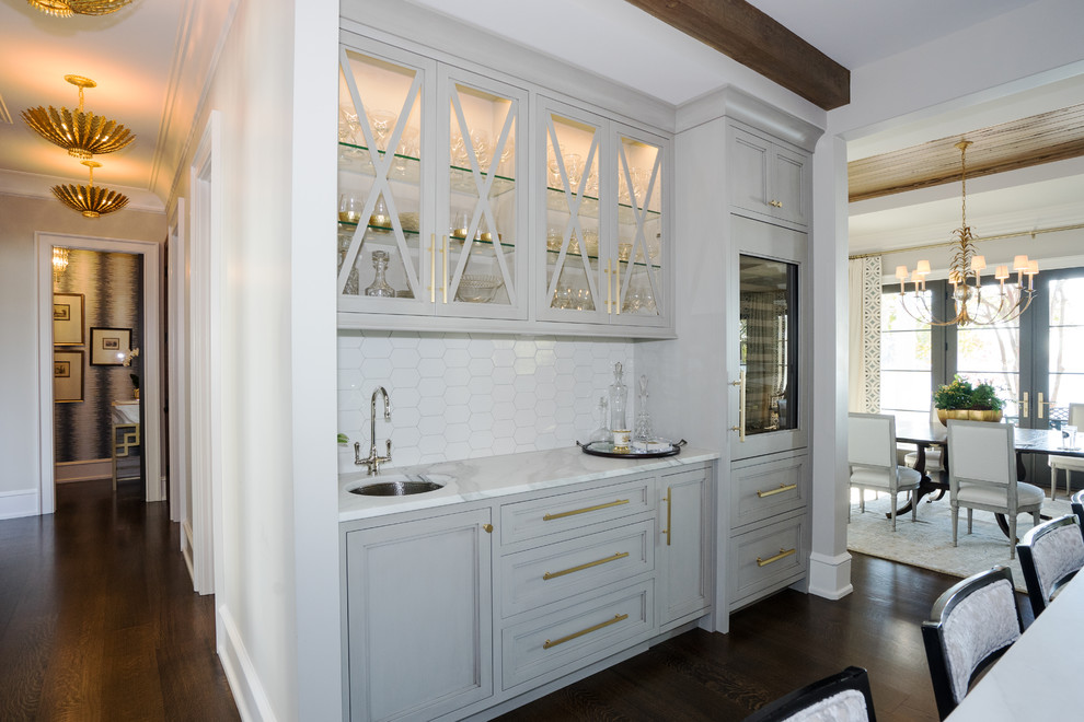 Idéer för ett klassiskt vit kök, med en undermonterad diskho, luckor med profilerade fronter, grå skåp, marmorbänkskiva, vitt stänkskydd, stänkskydd i keramik, integrerade vitvaror, mörkt trägolv, en köksö och brunt golv