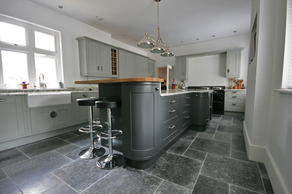 Mittelgroße Moderne Wohnküche in L-Form mit Landhausspüle, Marmor-Arbeitsplatte, Kalkstein und Kücheninsel in Sonstige
