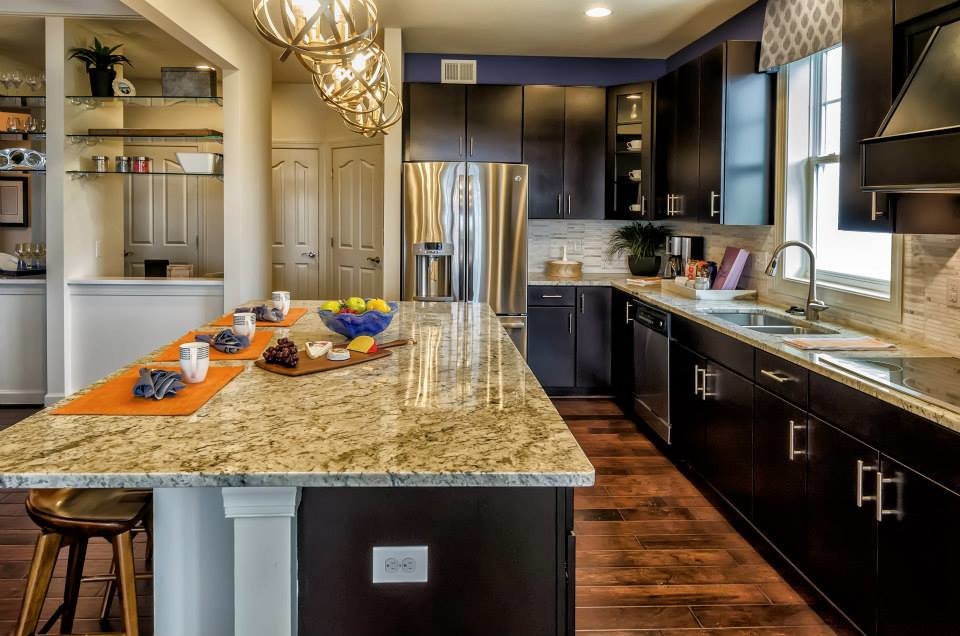 Foto di una cucina stile marinaro con ante in legno bruno, top in granito, paraspruzzi beige, elettrodomestici in acciaio inossidabile e pavimento in legno massello medio