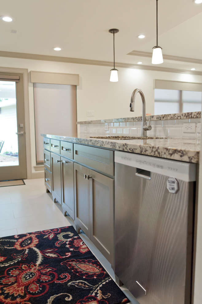 Inspiration for a mid-sized transitional galley porcelain tile kitchen remodel in Houston with an undermount sink, shaker cabinets, gray cabinets, granite countertops, white backsplash, subway tile backsplash, stainless steel appliances and a peninsula