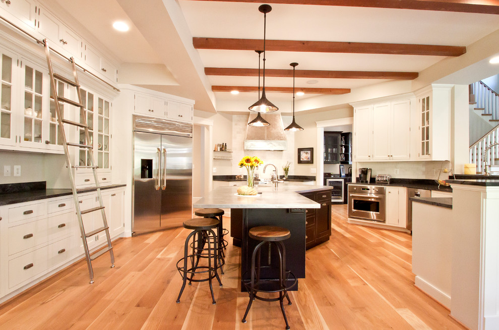Elegant u-shaped kitchen photo in DC Metro with stainless steel countertops, shaker cabinets, white cabinets and stainless steel appliances