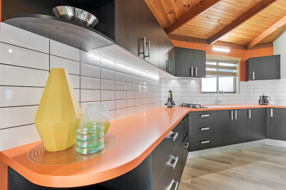 Источник вдохновения для домашнего уюта: маленькая отдельная, прямая кухня в стиле модернизм с монолитной мойкой, столешницей из акрилового камня, желтым фартуком, фартуком из плитки кабанчик и оранжевой столешницей для на участке и в саду