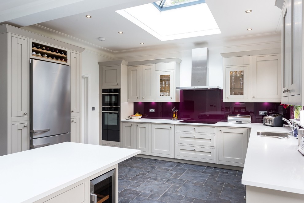Inspiration for a large u-shaped kitchen in London with shaker cabinets, white cabinets, pink splashback, glass sheet splashback and an island.