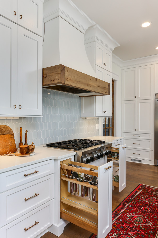 Open concept kitchen - large transitional l-shaped medium tone wood floor open concept kitchen idea in Raleigh with a farmhouse sink, recessed-panel cabinets, white cabinets, quartz countertops, blue backsplash, stainless steel appliances, an island and white countertops