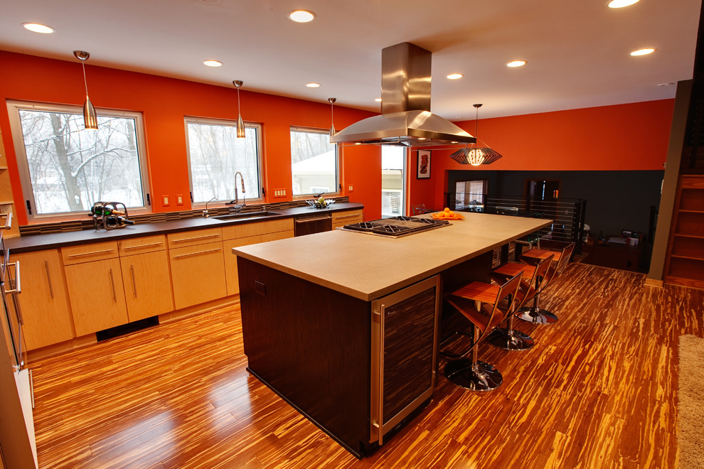Mid-sized trendy l-shaped bamboo floor eat-in kitchen photo in Milwaukee with an undermount sink, flat-panel cabinets, light wood cabinets, concrete countertops, brown backsplash, stainless steel appliances and an island