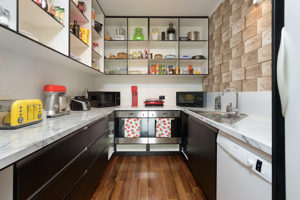 Cette image montre une arrière-cuisine minimaliste en U avec un évier 1 bac, un placard sans porte, un électroménager en acier inoxydable et un sol en bois brun.