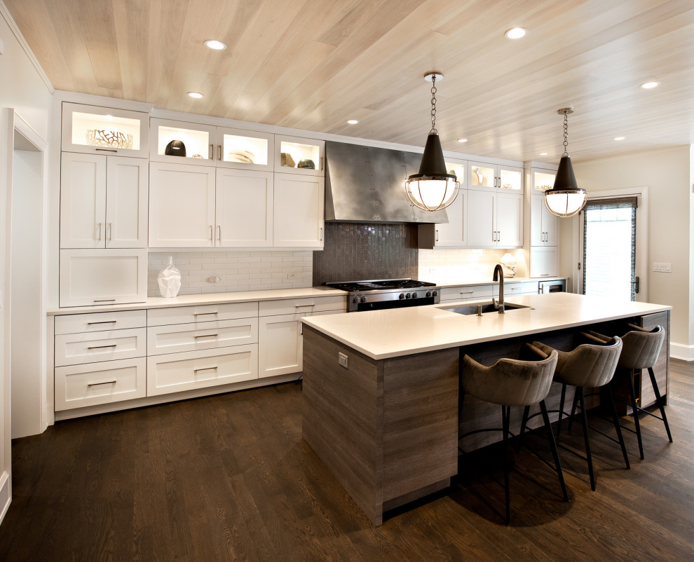 Example of a trendy brown floor and wood ceiling kitchen design in Chicago with white cabinets, quartzite countertops, multicolored backsplash, brick backsplash, stainless steel appliances, an island and white countertops