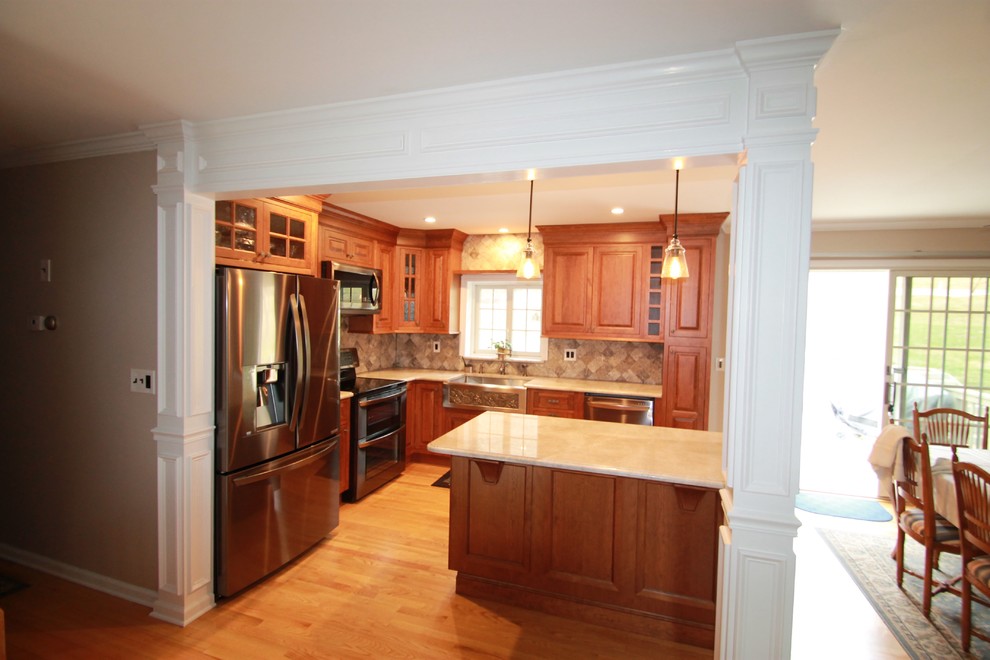 Exempel på ett mellanstort klassiskt kök, med en rustik diskho, luckor med upphöjd panel, skåp i mellenmörkt trä, granitbänkskiva, grått stänkskydd, stänkskydd i stenkakel, rostfria vitvaror, ljust trägolv och en köksö