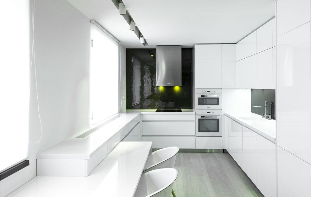 Photo of a medium sized modern u-shaped kitchen/diner in Other with an integrated sink, flat-panel cabinets, white cabinets, granite worktops, grey splashback, glass sheet splashback, white appliances, plywood flooring and a breakfast bar.