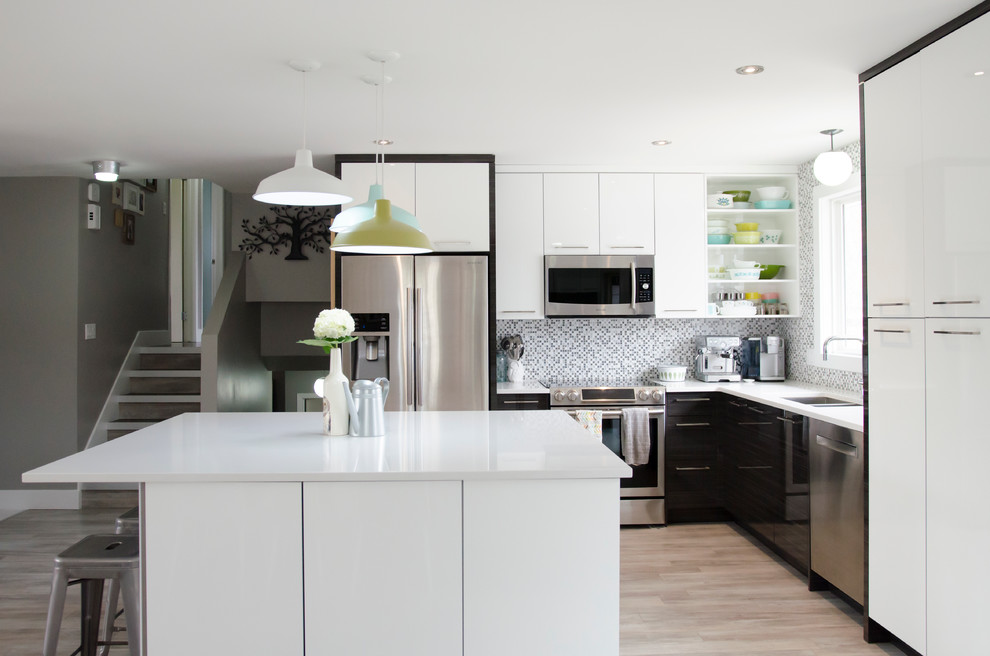 Bild på ett litet funkis kök, med en undermonterad diskho, släta luckor, vita skåp, bänkskiva i kvartsit, flerfärgad stänkskydd, stänkskydd i glaskakel, rostfria vitvaror, mellanmörkt trägolv och en köksö