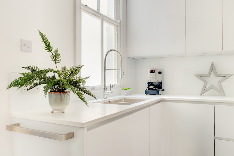 Foto di una cucina contemporanea con ante bianche, paraspruzzi bianco, paraspruzzi con lastra di vetro, parquet scuro, nessuna isola, pavimento marrone e top bianco