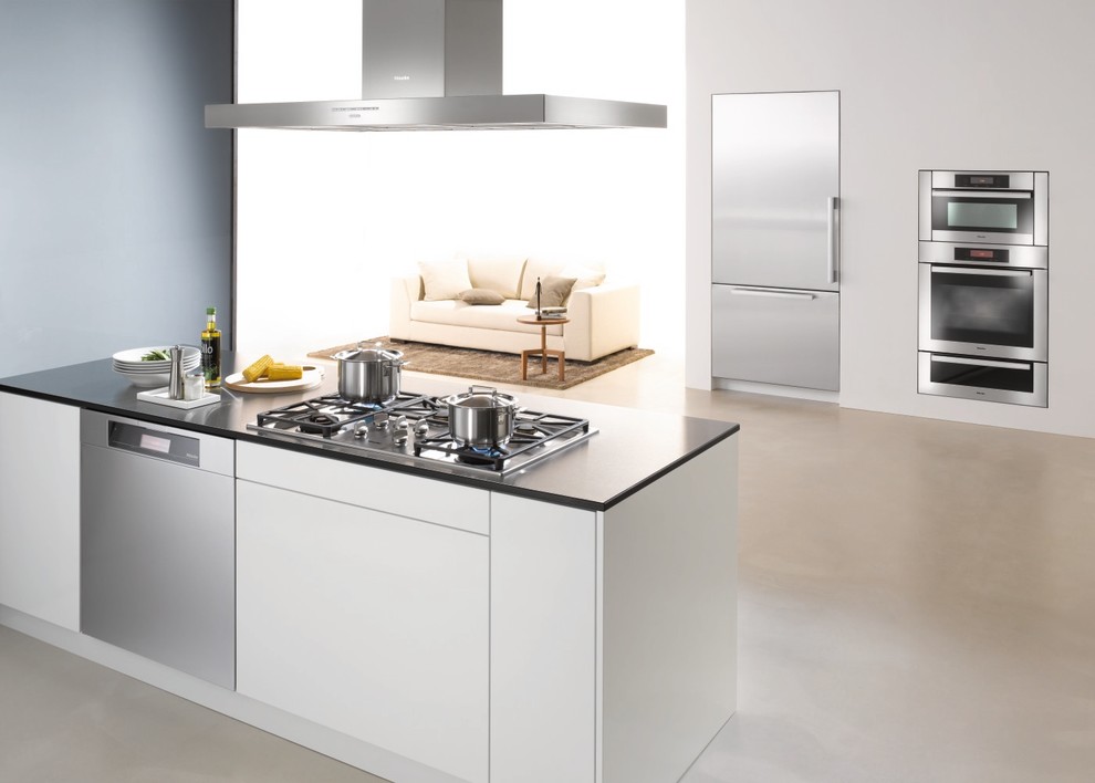 Modelo de cocina minimalista grande abierta con armarios con paneles lisos, puertas de armario blancas, electrodomésticos de acero inoxidable y península
