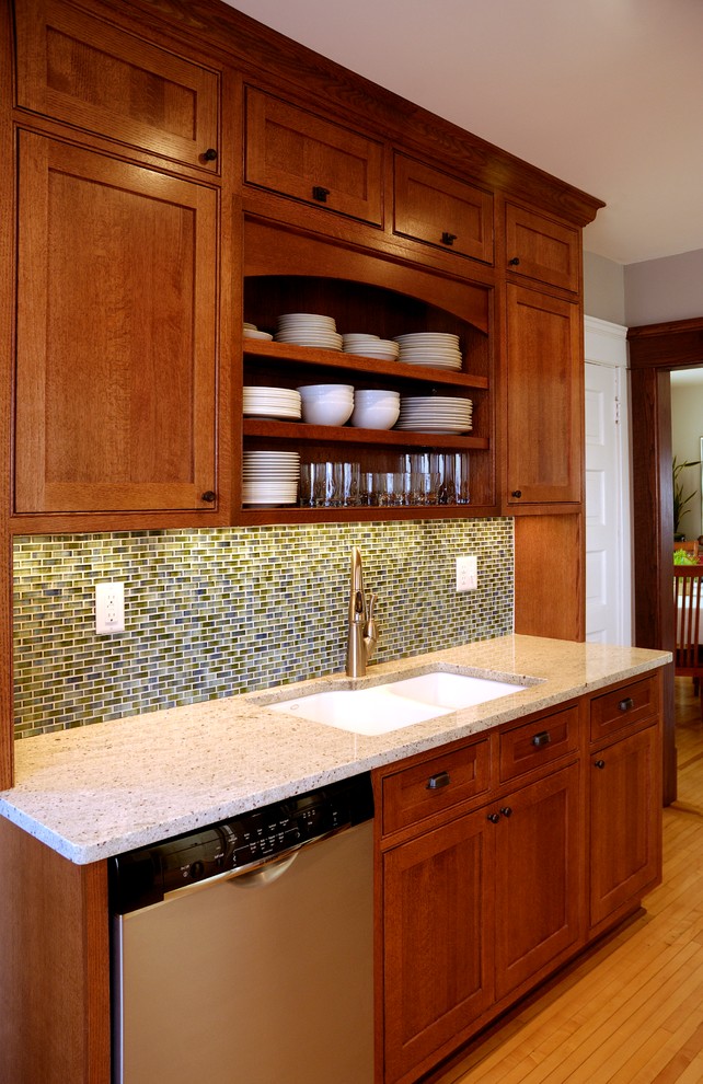 This is an example of a medium sized classic enclosed kitchen in Minneapolis with a submerged sink, beaded cabinets, medium wood cabinets, granite worktops, blue splashback, glass tiled splashback, stainless steel appliances, light hardwood flooring and no island.
