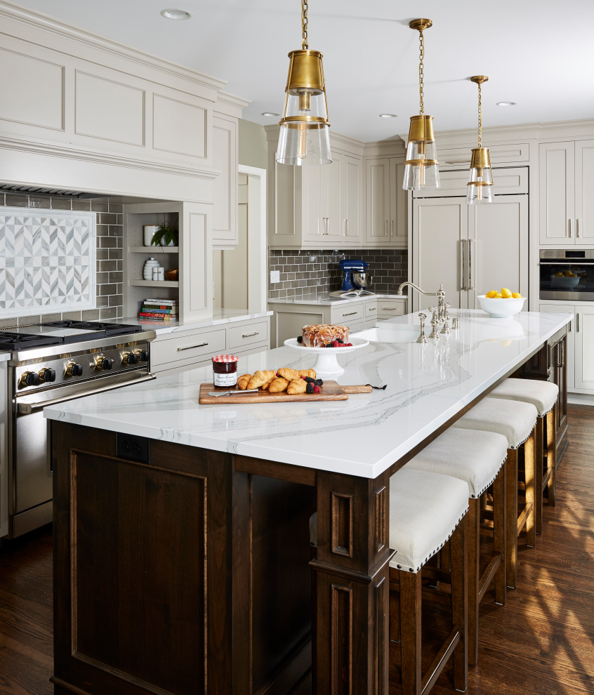 Design ideas for a traditional l-shaped kitchen in Minneapolis with a belfast sink, recessed-panel cabinets, grey cabinets, grey splashback, metro tiled splashback, stainless steel appliances, dark hardwood flooring, an island, brown floors and white worktops.