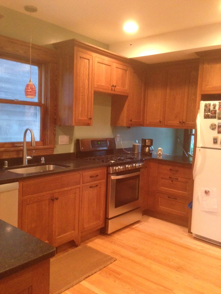 Medium sized classic u-shaped kitchen/diner in Minneapolis with a breakfast bar, a submerged sink, shaker cabinets, medium wood cabinets, granite worktops, stainless steel appliances and light hardwood flooring.