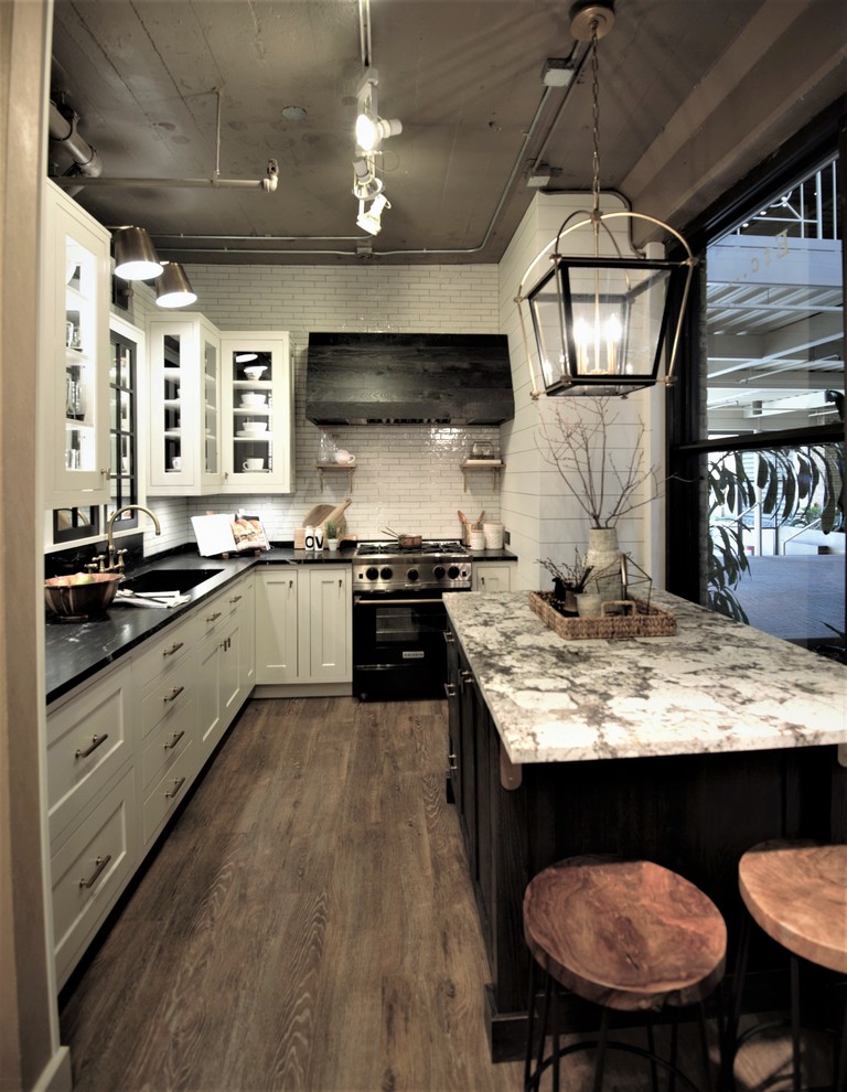 Foto di un cucina con isola centrale country con pavimento in vinile, ante bianche, top in granito e paraspruzzi bianco