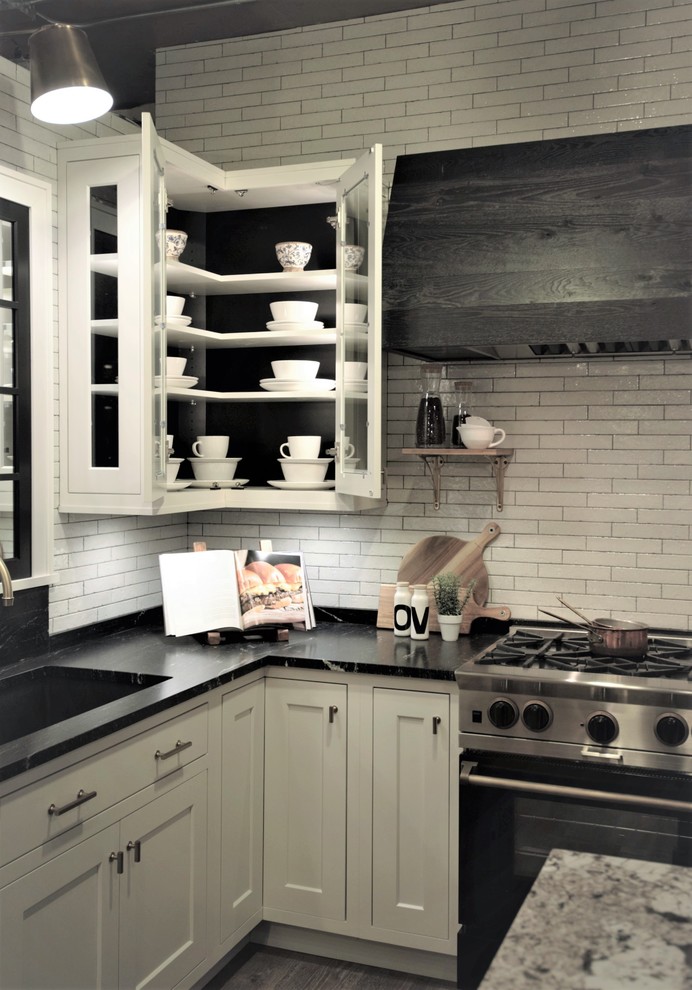 Idee per un cucina con isola centrale country con ante bianche, top in granito, paraspruzzi bianco e pavimento in vinile