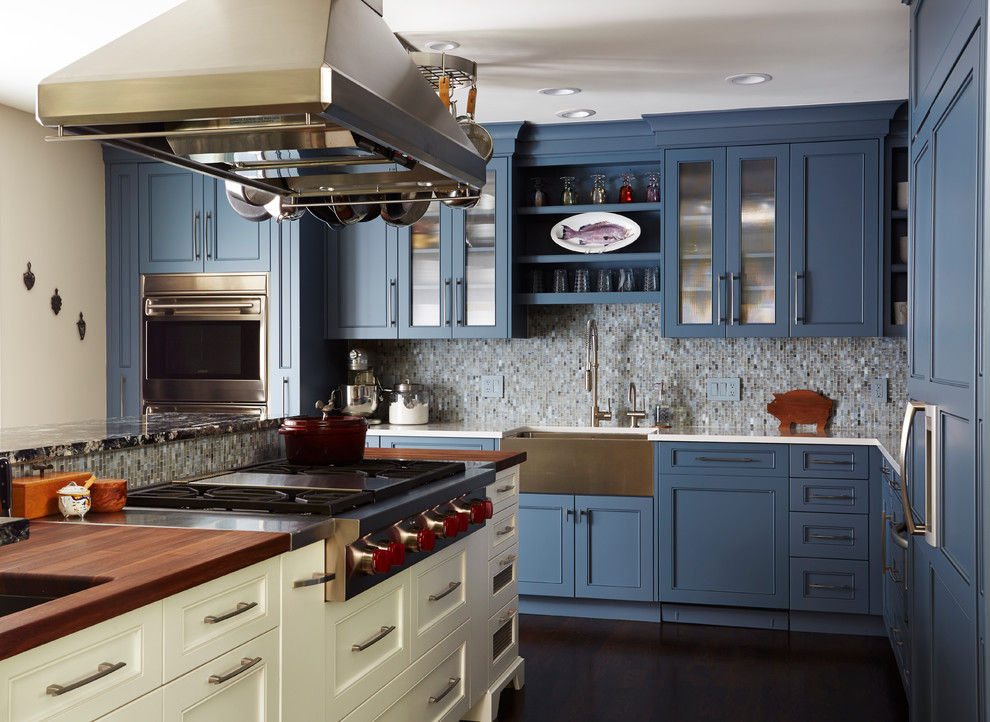 Bild på ett vintage kök, med luckor med infälld panel, blå skåp, stänkskydd i mosaik, rostfria vitvaror och en köksö