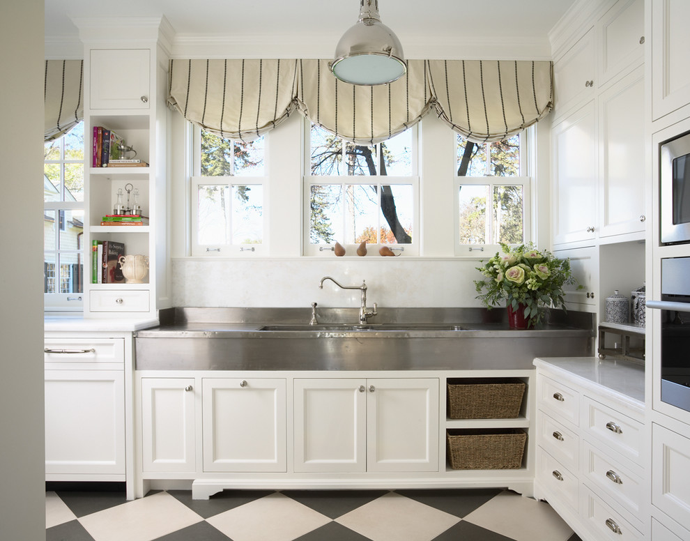 На фото: кухня в классическом стиле с монолитной мойкой, фасадами в стиле шейкер, белыми фасадами и разноцветным полом