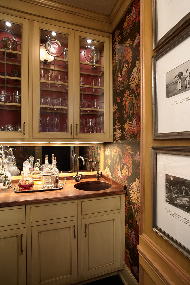 На фото: кухня в классическом стиле с стеклянными фасадами, деревянной столешницей и обоями на стенах